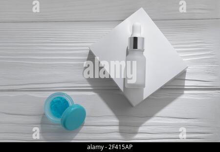 Pipettierflasche auf weißem Karton und blaues Gel auf öffnen Weißer Holztisch Stockfoto