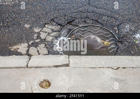 Kanalschächte auf Asphalt. Die Abdeckung des Kanalabflusses auf den Straßen Moskaus Russlands.. Die Abdeckung des Kanalabflusses auf den Straßen Moskaus Russlands. Stockfoto