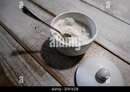 Offene Zuckerdose mit Schaufel auf altem Holztisch von oben gesehen, Copyspace. Offene Zuckerdose mit Schaufel auf altem Holztisch von oben gesehen Stockfoto