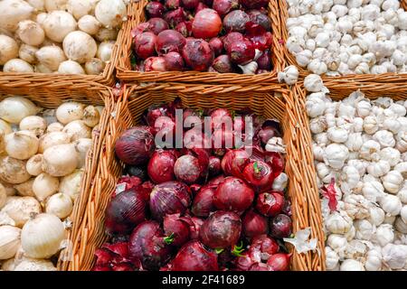 Lila und weiße Zwiebeln in vielen auf dem lokalen Bauernmarkt in Kisten ausgestellt. Lila und weiße Zwiebeln in Hülle und Fülle auf dem lokalen Bauernmarkt. Stockfoto