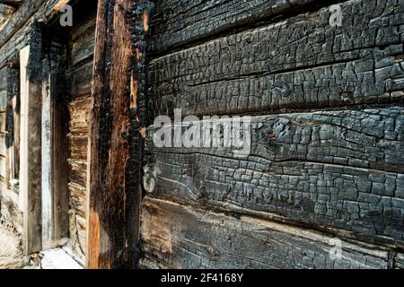 Verkohlte schwarze Holzwand. Winkel Bild einer verbrannten Bretter von Slum Haus Nahaufnahme. Verkohlte schwarze Holzwand. Winkel Bild von einem verbrannten Bretter von Slum Haus Stockfoto