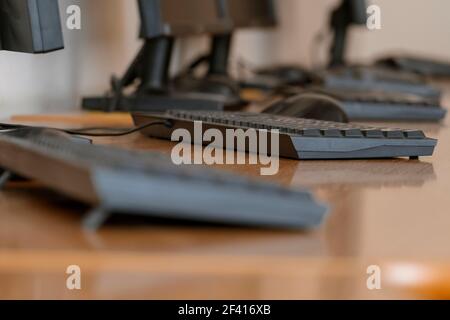 Büroinnenraum mit Computern auf Tischen, aufgenommen aus dem niedrigen Winkel mit flachem Freiheitsgrad. Büroeinrichtung mit Computern auf Tischen Stockfoto