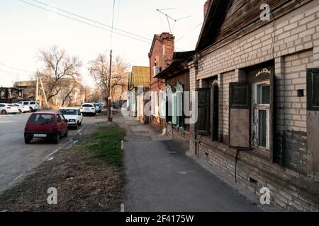 Astrachan, Russland 12. April 2018: In der Straße von Astrachan im sonnigen Frühlingstag mit teuren Autos geparkt über alte Slum Häuser. Astrachan, Russland 12. April 2018: In der Straße von Astrachan im sonnigen Frühlingstag mit Autos geparkt über alte Häuser Stockfoto