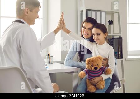 Happy Little girl Patient gibt fünf lächelnde männliche Kinderarzt nach der medizinischen Untersuchung. Stockfoto