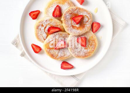 Quark Pfannkuchen mit Erdbeeren Schichten und Honig. Gesundes Frühstück. Ansicht von oben, flach Stockfoto