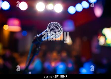 Öffentliche Aufführung auf der Bühne Mikrofon auf der Bühne vor dem Hintergrund der Auditorium. Geringe Tiefenschärfe. Öffentliche Aufführung auf der Bühne. Stockfoto