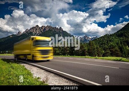 Kraftstoff Lkw Rast auf der Autobahn im Hintergrund die Alpen. Lkw Auto in Bewegungsunschärfe. Stockfoto