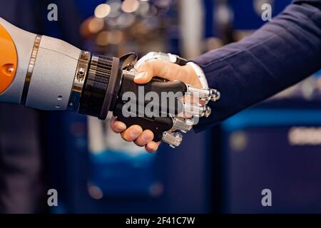 Hand eines Geschäftsmannes Händeschütteln mit einem Android Roboter. Das Konzept der menschlichen Interaktion mit der künstlichen Intelligenz. Stockfoto