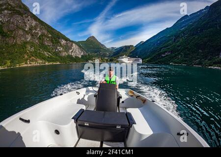 Mann, der ein Motorboot. Geiranger Fjord, schöne Natur Norwegen. Sommer Urlaub. Geiranger Fjord, einem UNESCO-Weltkulturerbe. Stockfoto