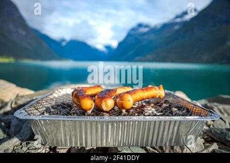 Grillen Würstchen auf Einweg Grill Gitter. Schöne Natur Norwegen natürliche Landschaft. Stockfoto