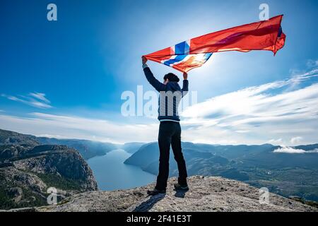 Frau mit einem wehende Flagge Norwegen auf dem Hintergrund der Natur Stockfoto