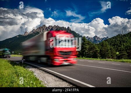 Kraftstoff Lkw Rast auf der Autobahn im Hintergrund die Alpen. Lkw Auto in Bewegungsunschärfe. Stockfoto