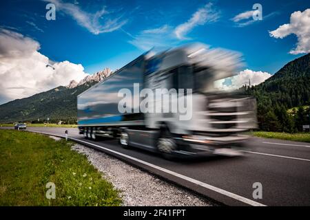 Kraftstoff Lkw Rast auf der Autobahn im Hintergrund die Alpen. Lkw Auto in Bewegungsunschärfe. Stockfoto