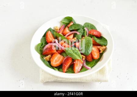 Gesundes Frühstück mit Obstsalat aus Erdbeere, Spinat und Walnuss. Nahaufnahme Stockfoto