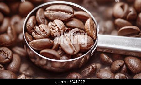 Nahaufnahme von Kaffeesamen. Duftende Kaffeebohnen sind gerösteter Rauch kommt von Kaffeebohnen. Stockfoto