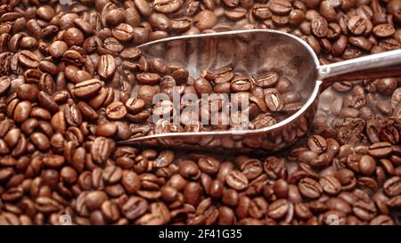 Nahaufnahme von Kaffeesamen. Duftende Kaffeebohnen sind gerösteter Rauch kommt von Kaffeebohnen. Stockfoto