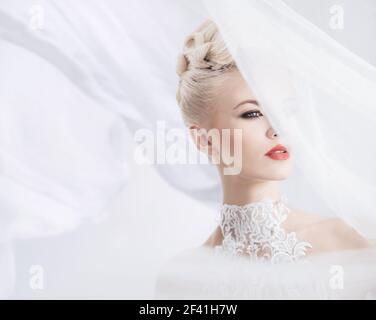 Elegante blonde Frau mit einem hellen Schleier auf dem Kopf Stockfoto