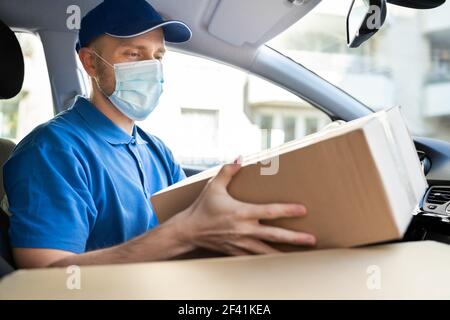 Lieferung Arbeiter Mann In Medizinischen Gesichtsmaske Im Auto Stockfoto