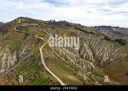 Luftaufnahme von Calanchi di atri, die durch Bodenerosion in Italien entstanden ist, Abruzzen, die eine Spur und Badlands auf einem Hügel hervorheben Stockfoto