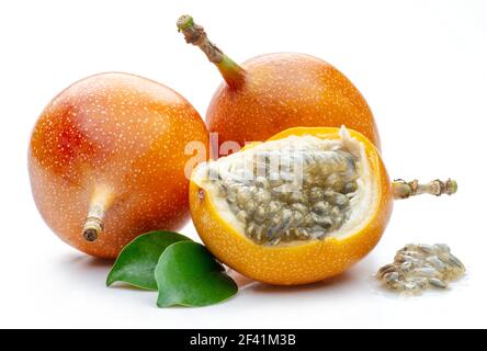 Granadilla mit Blättern und Passionsfrucht halb isoliert auf weißem Hintergrund. Stockfoto