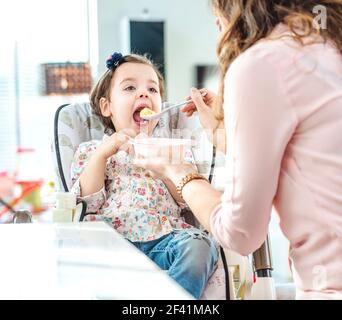 Fütterung ihrer geliebten Tochter Mutter Stockfoto