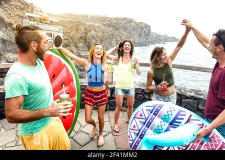 Junge Freunde Urlauber mit Spaß am natürlichen Pool auf Reisen Lage - Happy Millenial Menschen tanzen und trinken Cocktails Alternativer Strand Stockfoto