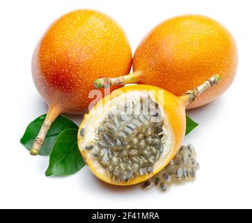 Granadilla mit Blättern und Passionsfrucht halb isoliert auf weißem Hintergrund. Stockfoto