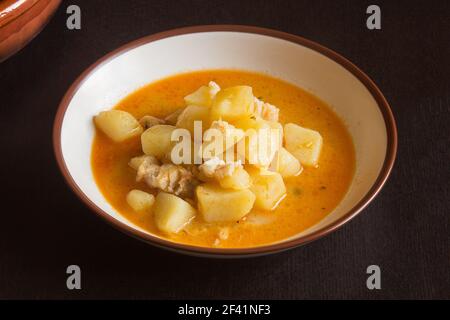 Präsentation Teller mit Kartoffeln mit Kabeljau in Gemüsesauce auf einem Holztisch. Kochen Rezepte mit Fisch zu Hause. Stockfoto