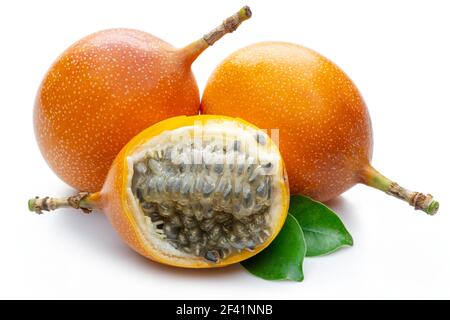 Granadilla mit Blättern und Passionsfrucht halb isoliert auf weißem Hintergrund. Stockfoto