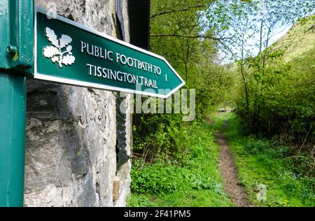 Ein Metall National Trust Wanderweg Schild mit der Aufschrift "öffentlicher Fußweg Tissington Trail 1 Meile", Wolfscote Dale, Staffordshire Derbyshire Grenze, England, Großbritannien Stockfoto