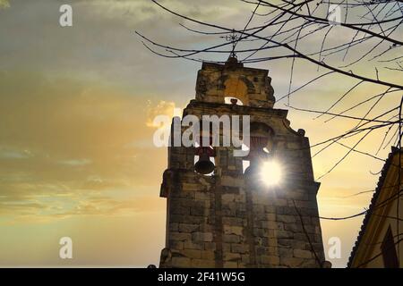 Sonnenstrahlen durch den Glockenturm der Santo Domingo Kirche In Granada (Spanien) bei Sonnenuntergang Stockfoto