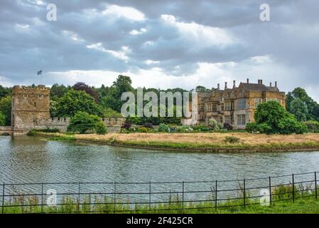 Broughton Castle, in der Nähe von Banbury, Oxfordshire, mit Moathouse, von den Feldern an den gegenüberliegenden Seiten des Grabens genommen. Künstlerischer Himmel. Stockfoto