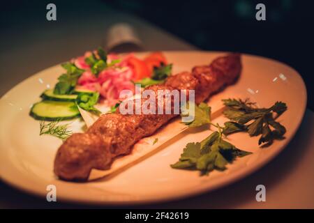 Saftige Dicke saftige Portionen gegrilltes Filet Steak mit Tomaten und gebratenem Gemüse auf einem alten Holzbrett serviert Stockfoto