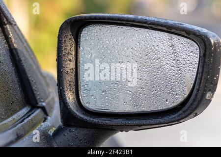 Ein Wassertropfen auf den Rückspiegel eines Autos. Stockfoto