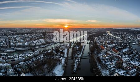 Panorama der Stadt Regensburg in Bayern mit der Donau der Dom und die Steinbrücke im Winter mit Eis und Schnee bei Sonnenuntergang, Deutschland Stockfoto