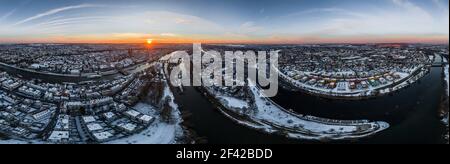 Panorama der Stadt Regensburg in Bayern mit der Donau der Dom und die Steinbrücke im Winter mit Eis und Schnee bei Sonnenuntergang, Deutschland Stockfoto