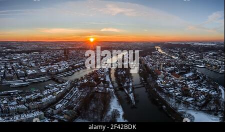 Panorama der Stadt Regensburg in Bayern mit der Donau der Dom und die Steinbrücke im Winter mit Eis und Schnee bei Sonnenuntergang, Deutschland Stockfoto