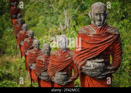 Hunderte von alten Statuen buddhistischer Mönche, die Almosen sammeln, umgeben den Win sein Taw Ya Buddha in Mawlamyine, Myanmar (Burma). Stockfoto