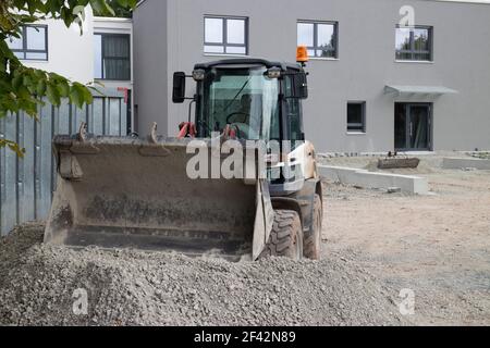 Kleiner Bagger gräbt Kies auf einer Baustelle Stockfoto