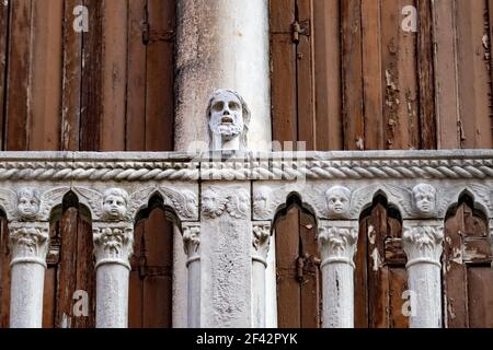 Nahaufnahme einer Männerkopfskulptur an einer Zaunwand mit verängstigten Gesichtsausdrücken, Venetien, Italien Stockfoto