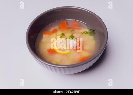 Cremige Suppe mit Lachs in Schüssel und Scheiben Roggenbrot auf einem grauen strukturierten Hintergrund, selektiver Fokus Stockfoto