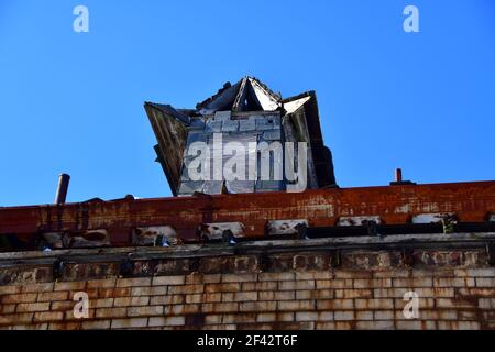 Verwittert, rostige alte Kuppel auf einem alten Biulding im Sonnenlicht mit Holz- und Metallreparaturen. Stockfoto