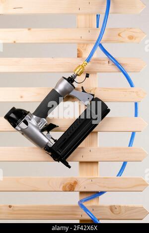 Ein Druckluftnagler mit Druckschlauch auf einem Holz Zaun Stockfoto