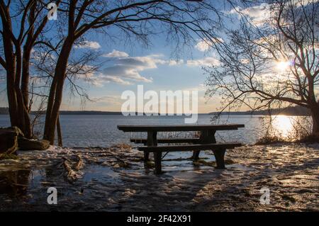 Spätnachmittagssonne im Winter mit Picknicktisch mit Eiszapfen entlang des Potomac River im Riverside Park, Alexandria, VA Stockfoto