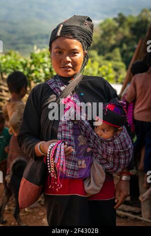 Porträt einer erwachsenen Frau des Stammes der eng, die Baby im Schal trägt, in der Nähe von Kengtung, Myanmar Stockfoto