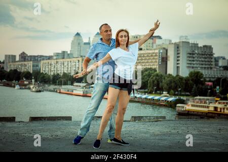 Dnepropetrovsk, Ukraine - 08,09.2017: Fröhliche Städter tanzen auf dem Platz in der Stadt bei Sonnenaufgang. Ein paar junge Leute tanzen gerne. Stockfoto