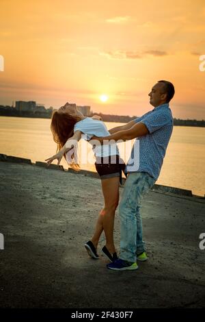 Dnepropetrovsk, Ukraine - 08,09.2017: Fröhliche Städter tanzen auf dem Platz in der Stadt bei Sonnenaufgang. Ein paar junge Leute tanzen gerne. Stockfoto