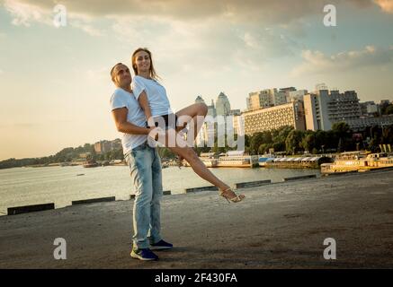 Dnepropetrovsk, Ukraine - 08,09.2017: Fröhliche Städter tanzen auf dem Platz in der Stadt bei Sonnenaufgang. Ein paar junge Leute tanzen gerne. Stockfoto