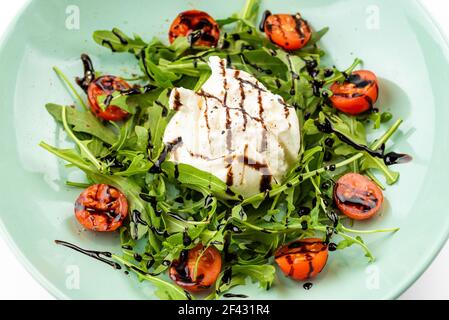 italienische Buratta mit Kirschtomaten und Rucola Stockfoto