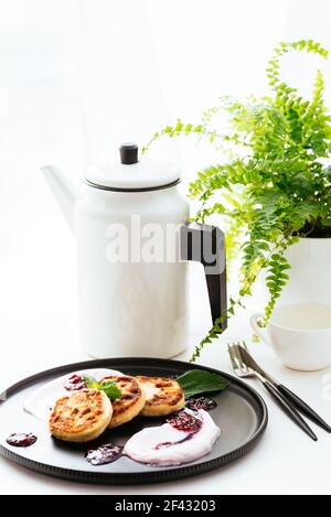 Käsepfannkuchen mit Marmelade auf schwarzem Teller Stockfoto